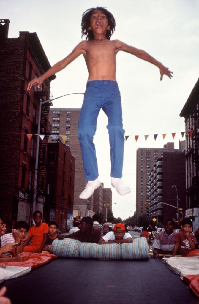 Un jeune garçon saute dans les airs dans les rues de New York.